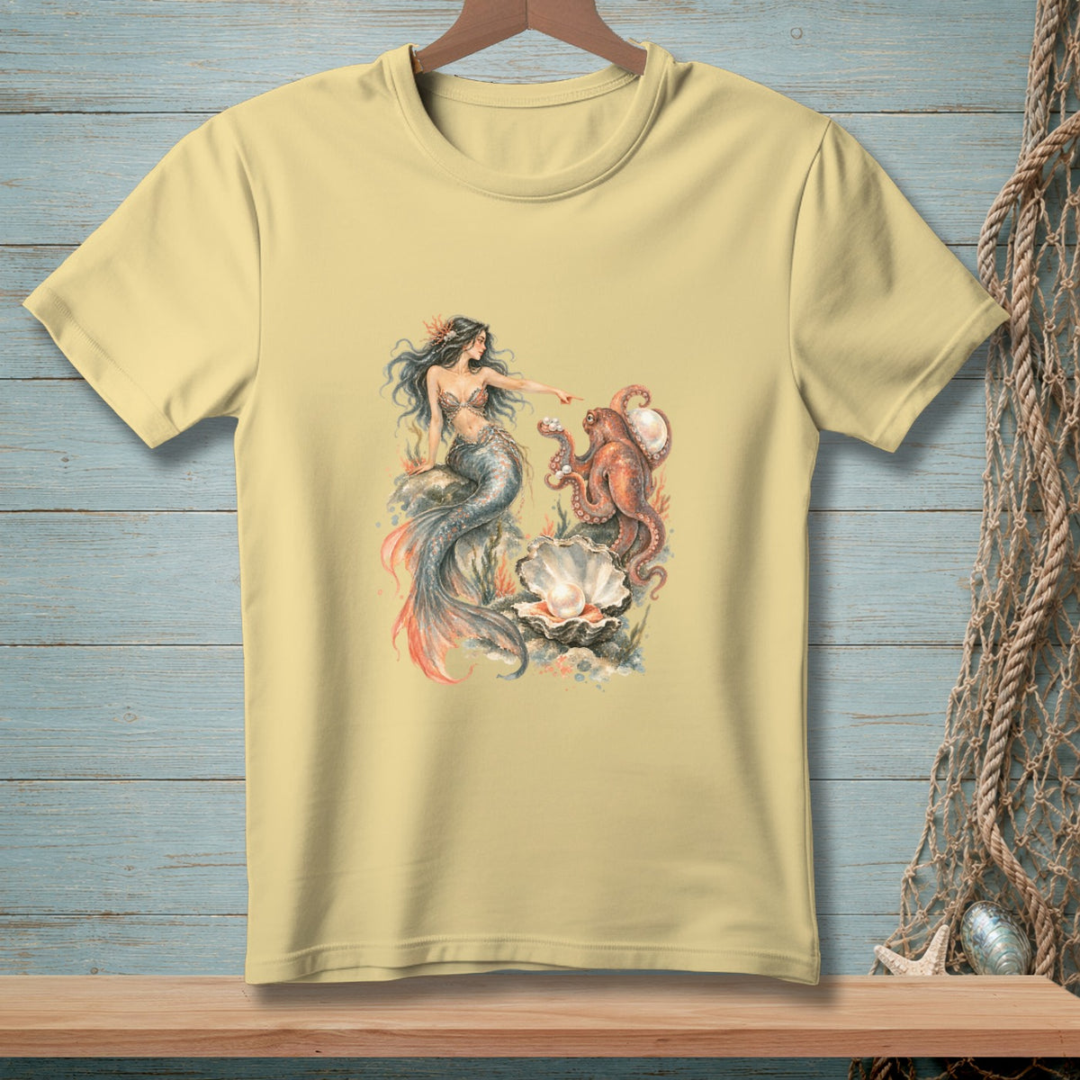 Light yellow t-shirt with mermaid and octopus reaching for a pearl.