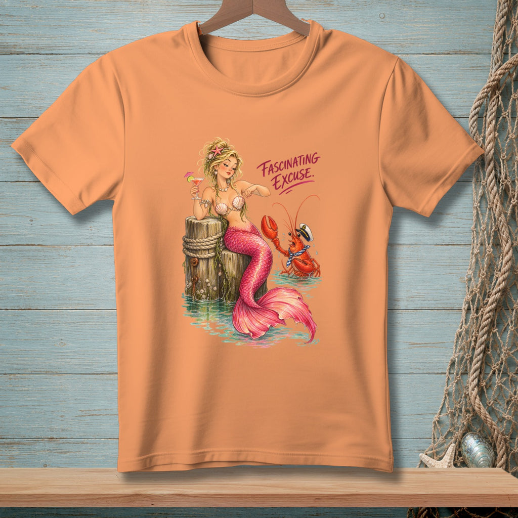 Peach t-shirt with mermaid holding a drink and a lobster beside a wooden post.