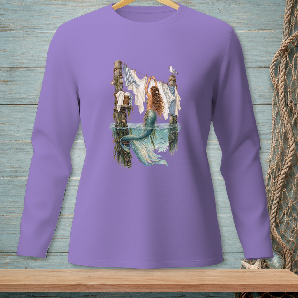 Mermaid hangs laundry on a clothesline next to a weathered post in the ocean.