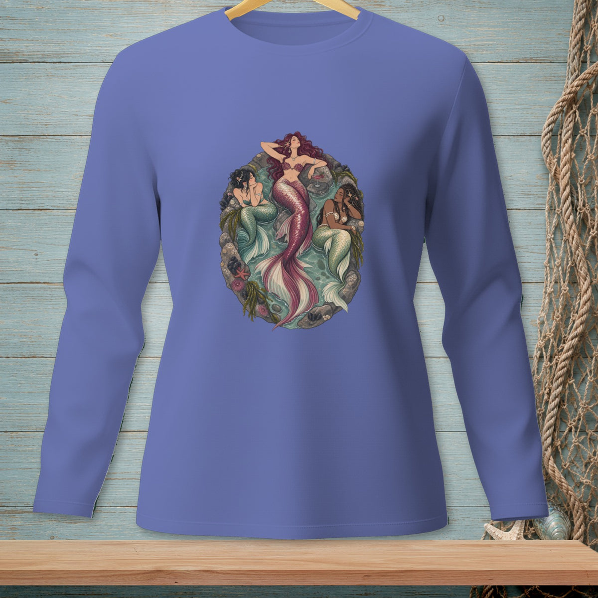 Long-sleeve purple shirt with a central graphic of three mermaids in an oval frame.