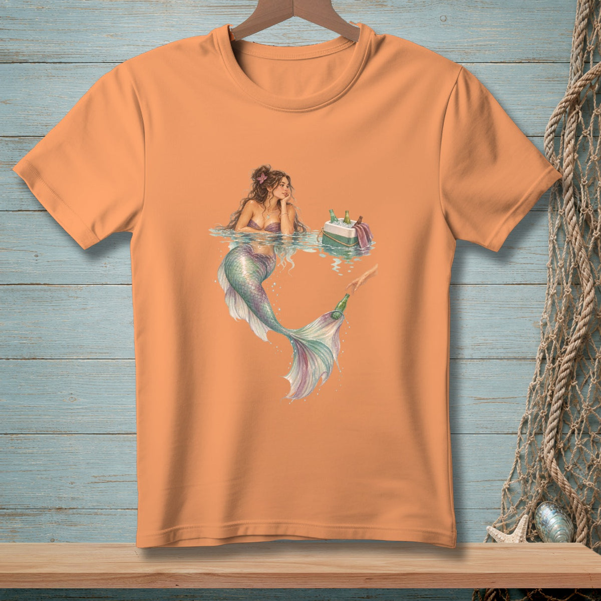 Orange t-shirt with a watercolor illustration of a mermaid reaching for a bottle from a cooler.