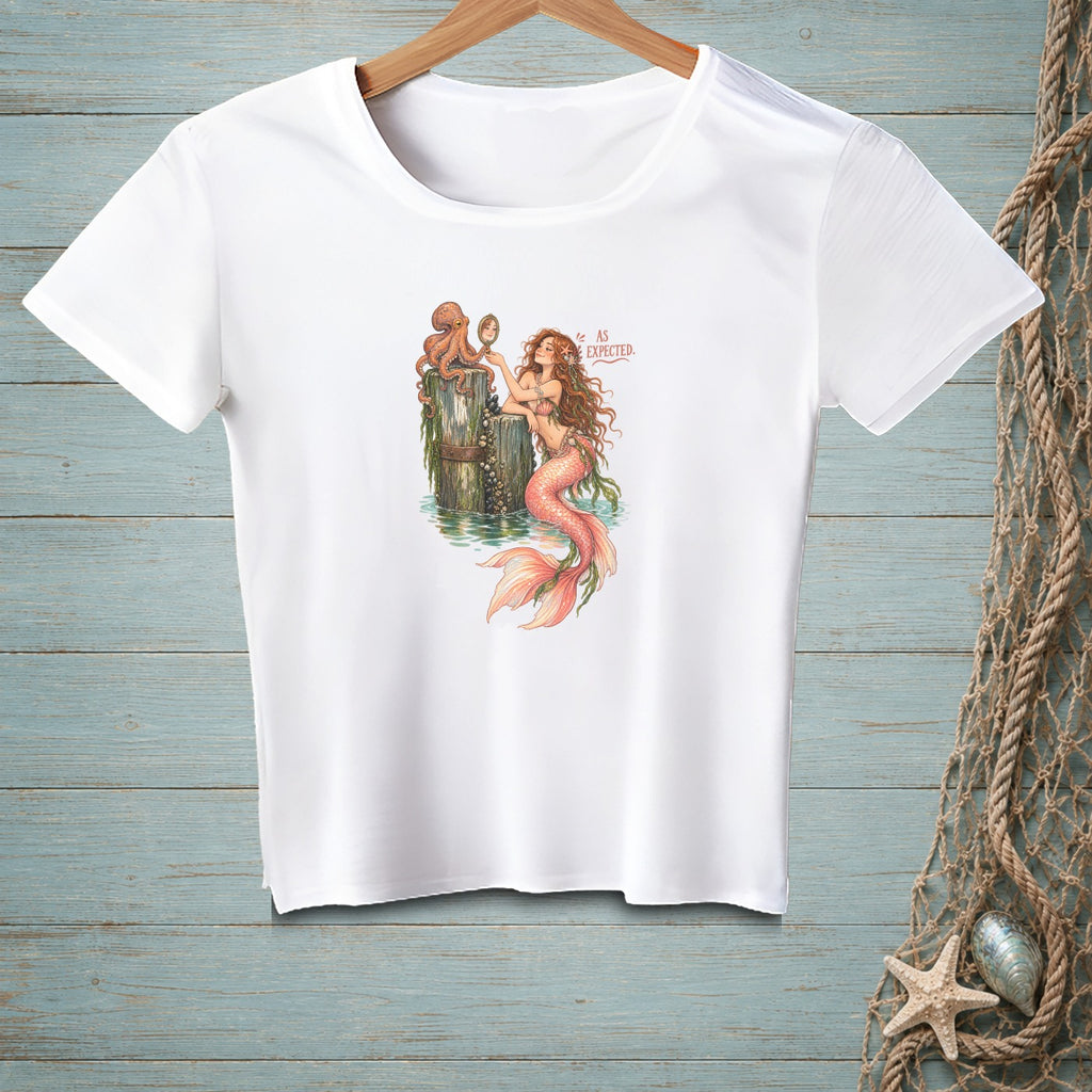 White t-shirt with illustration of mermaid and octopus looking in mirror, text "AS EXPECTED".