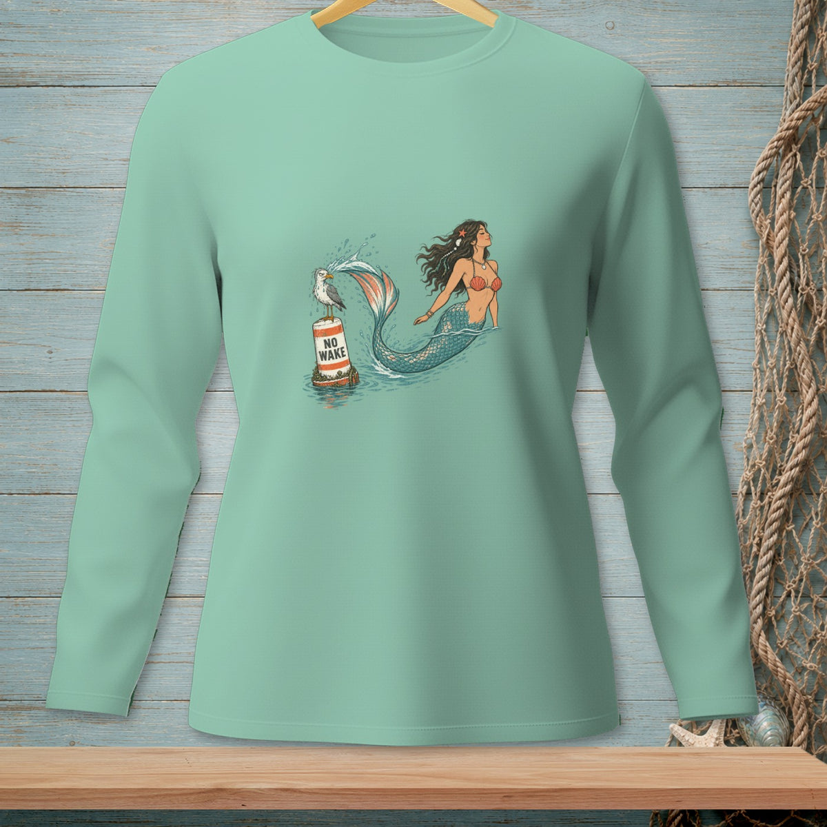 Mint green long-sleeve shirt with a graphic of a mermaid, a buoy, and a seagull.