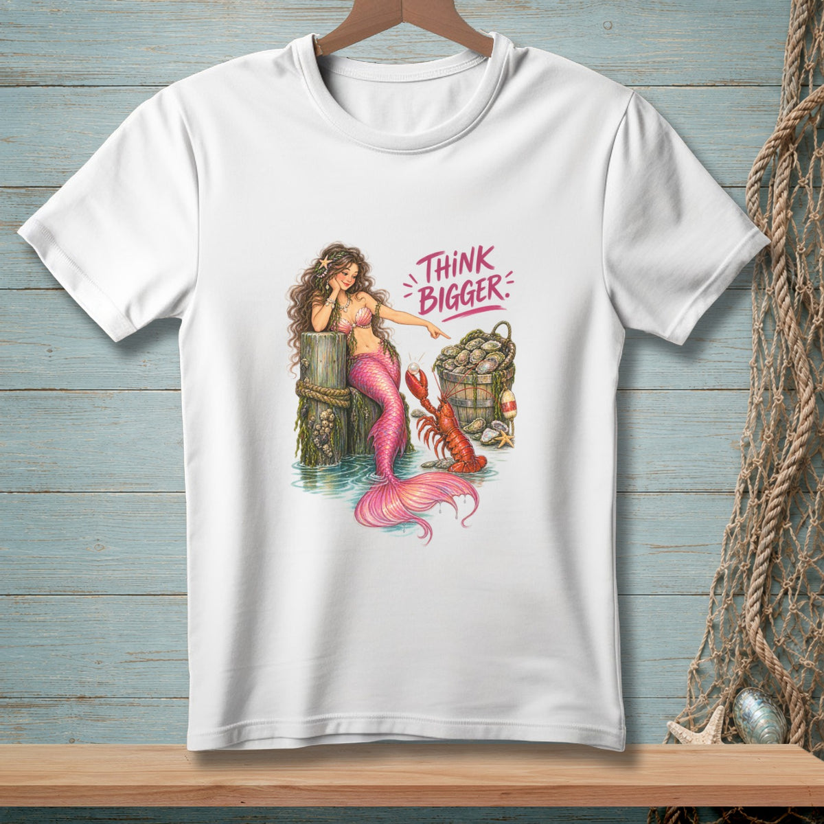 White t-shirt with mermaid pointing at lobster and saying "Think Bigger".
