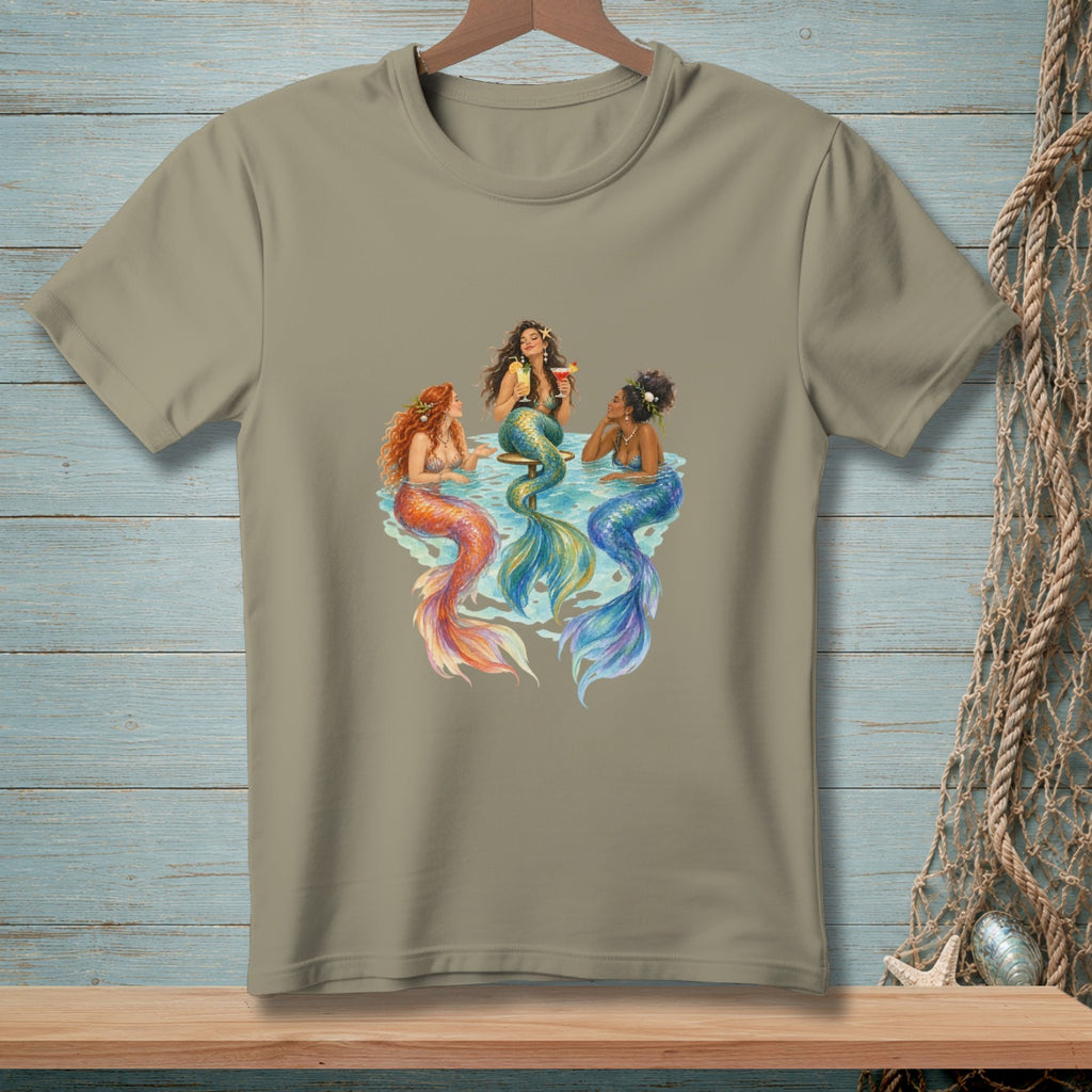 T-shirt graphic of three mermaids with colorful tails gathered around a table.