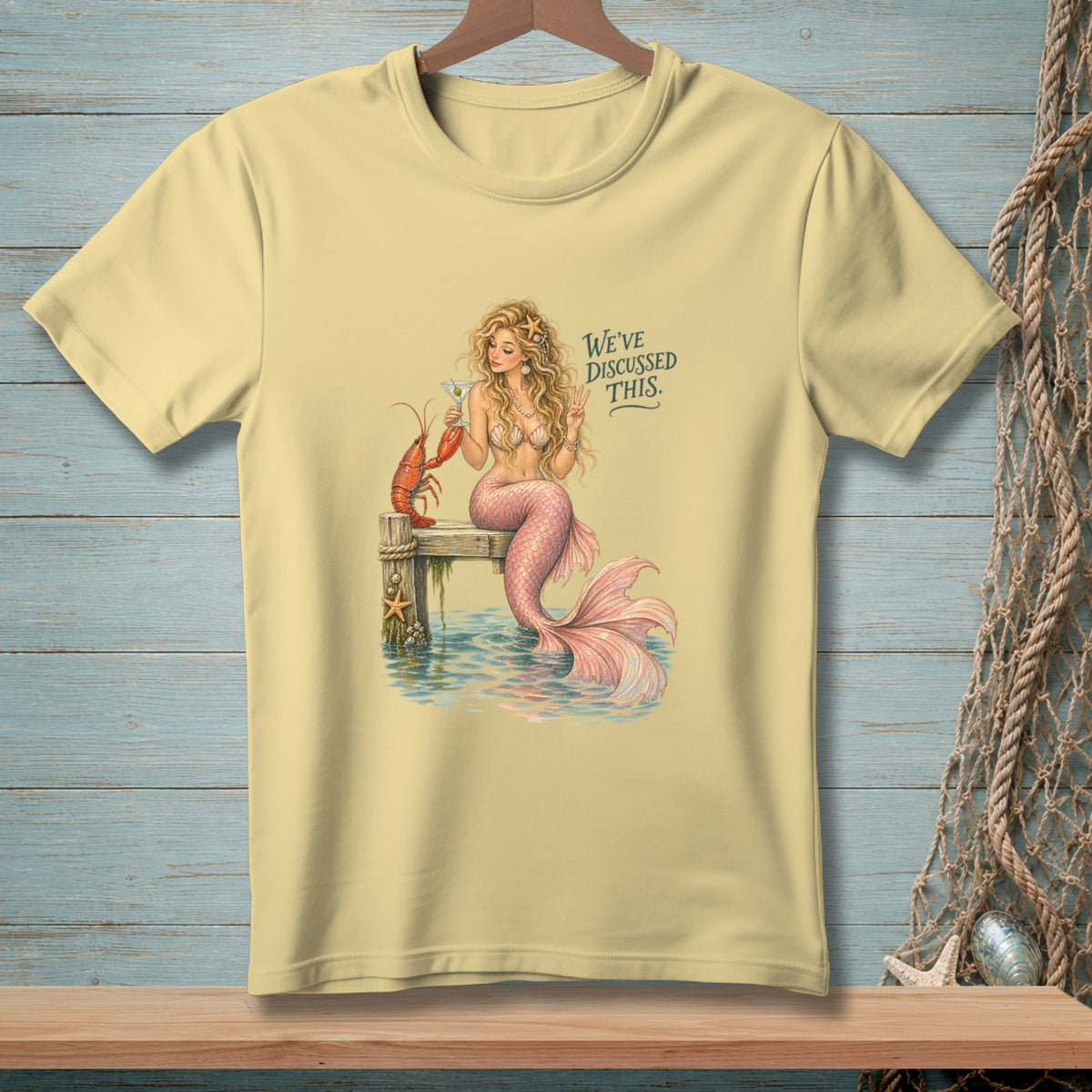 Yellow t-shirt with a mermaid, lobster, and text "WE'VE DISCUSSED THIS."
